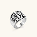 Silver 316L stainless steel men's signet ring with raised knight shield, cross motif, and ornate blackened scrollwork detailing.