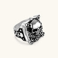 Silver-tone 316L stainless steel skull ring with crossbones, black enamel fill, studded details, and wide shank, 21mm top width.