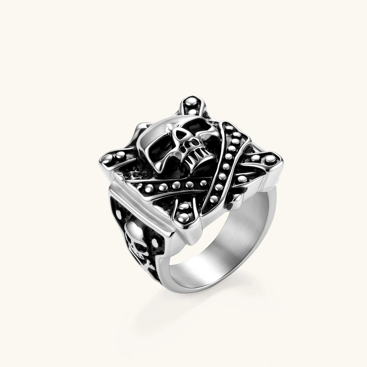 Silver-tone 316L stainless steel skull ring with crossbones, black enamel fill, studded details, and wide shank, 21mm top width.