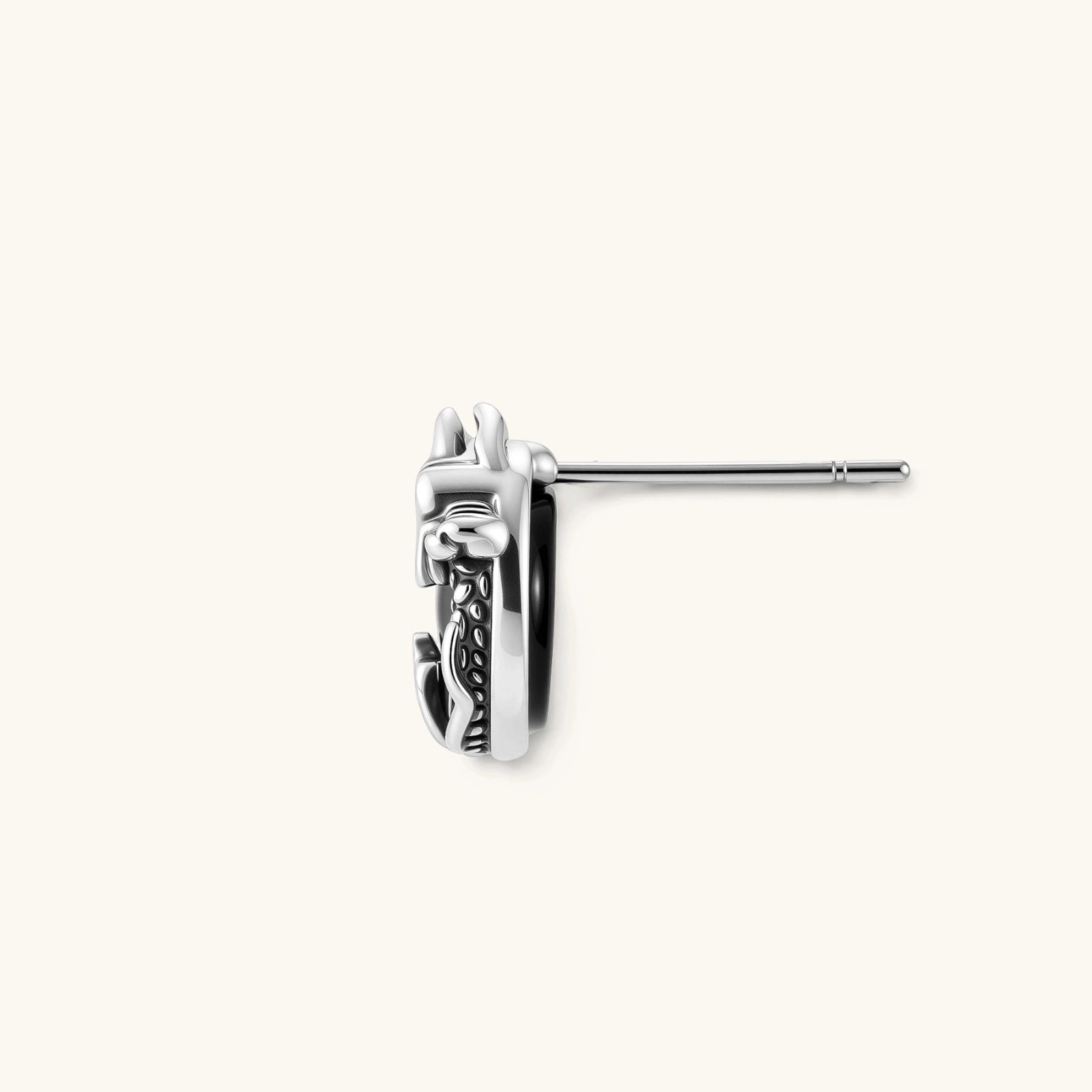 Silver stainless steel stud earring with coiled dragon motif wrapped around a black stone, shown from front and side.