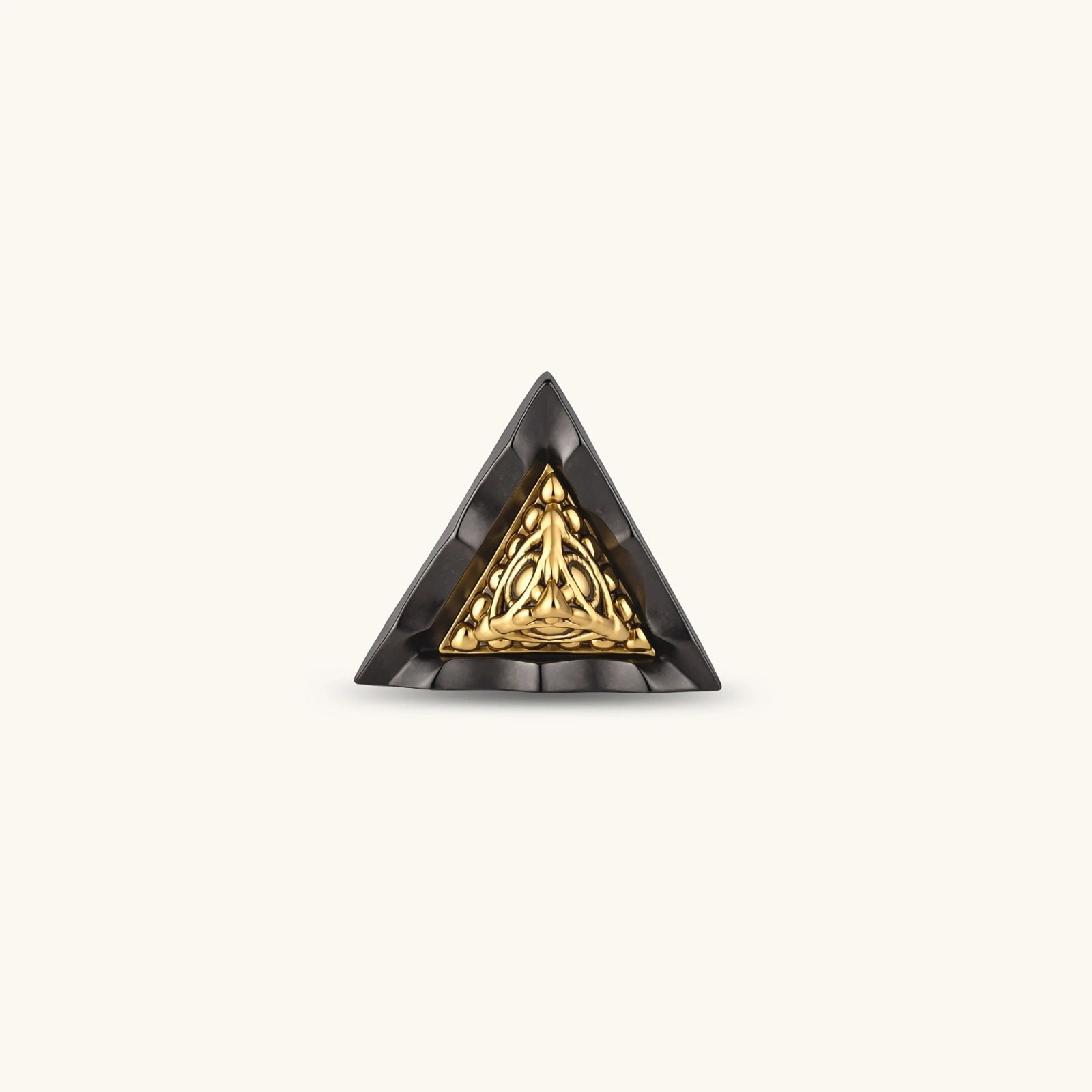 Single triangle stud earring with dark gunmetal outer frame and raised 18K gold-plated ornamental center, post back.