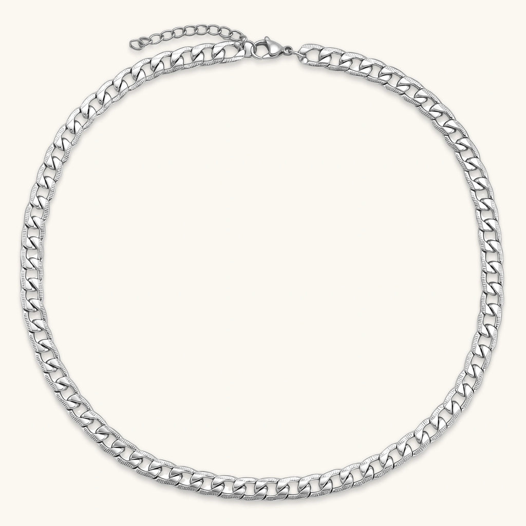 Silver 316L stainless steel carved curb chain necklace with lobster clasp and extender, 7.2mm wide, on cream background.