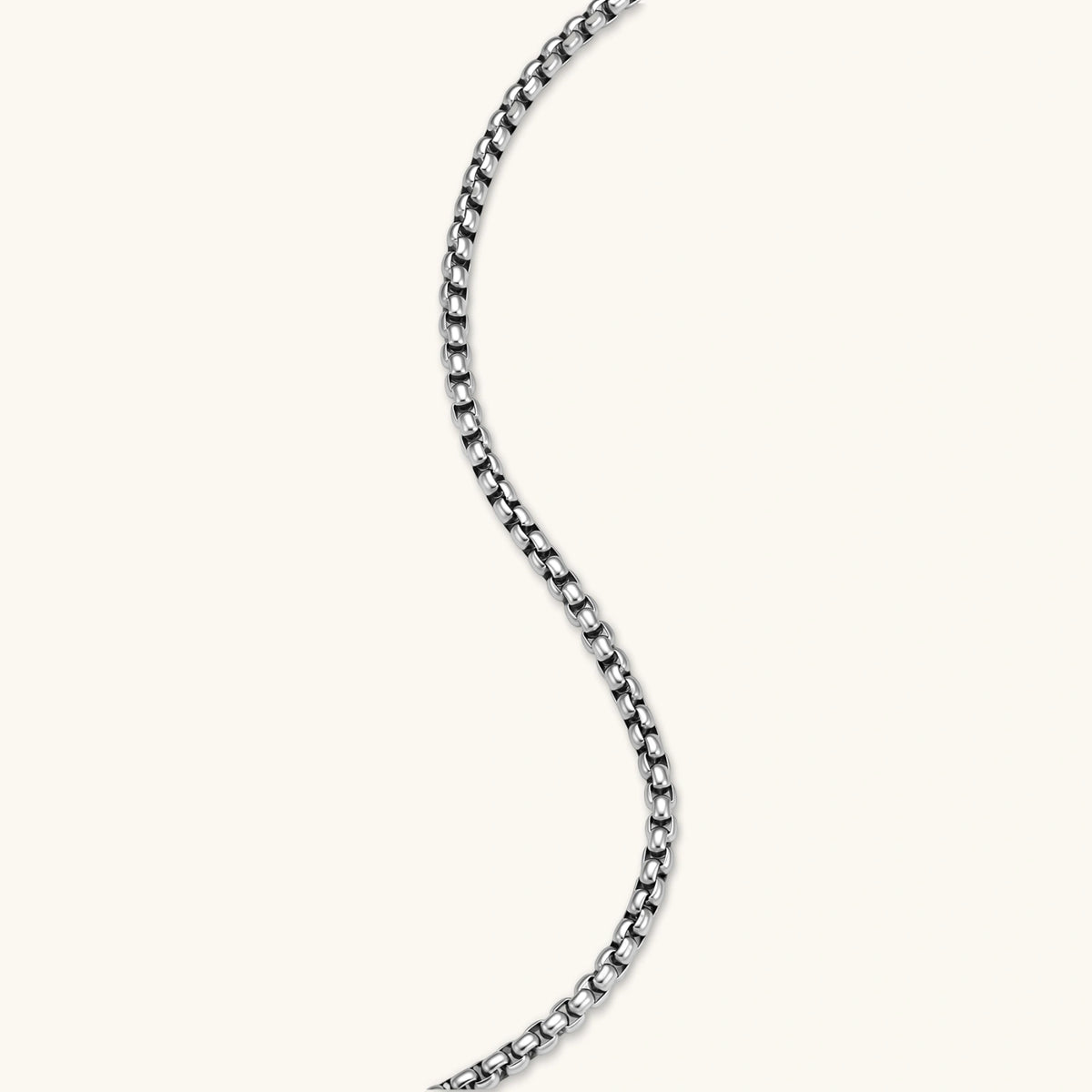 Silver stainless steel ankh pendant with skull motifs on vertical bar and textured ring top, on a box chain necklace.