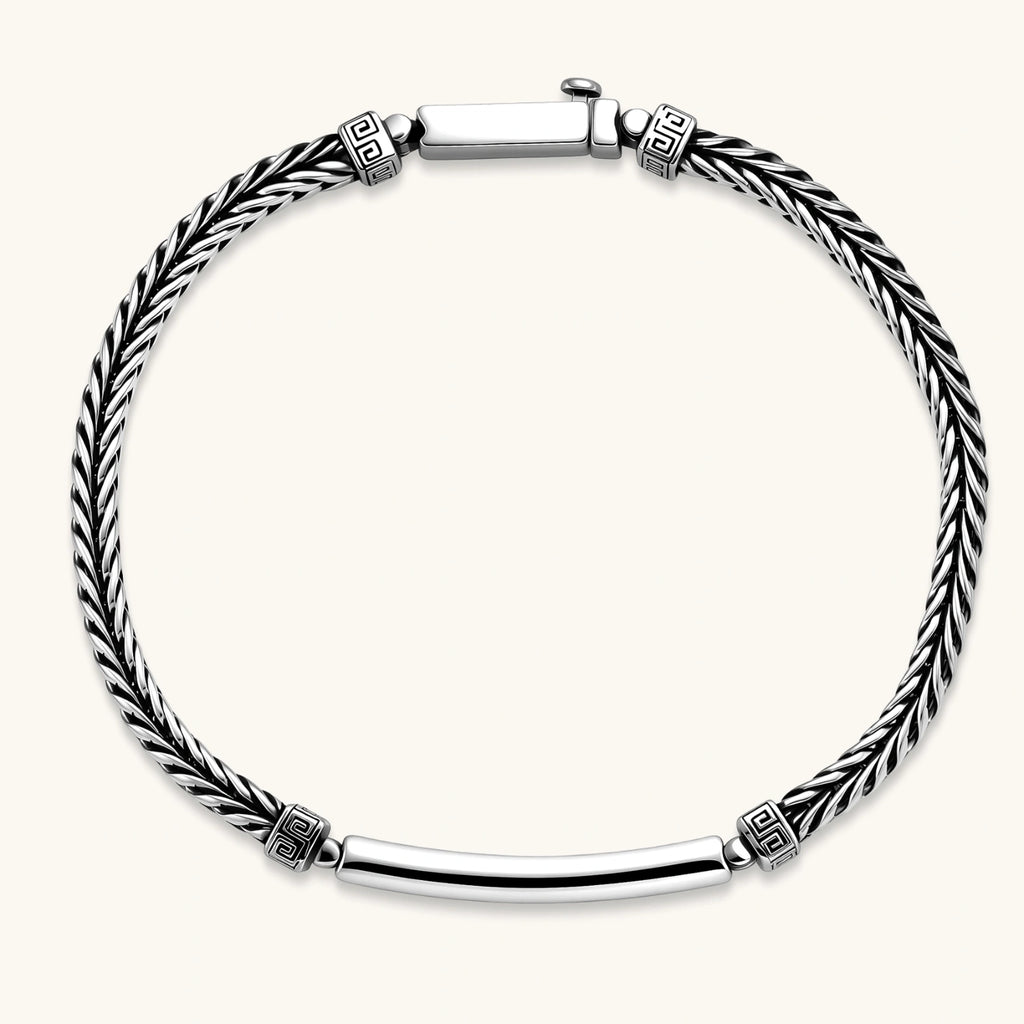 Silver stainless steel men's bracelet with braided foxtail chain, Greek key engraved bar, and decorative cube connectors.