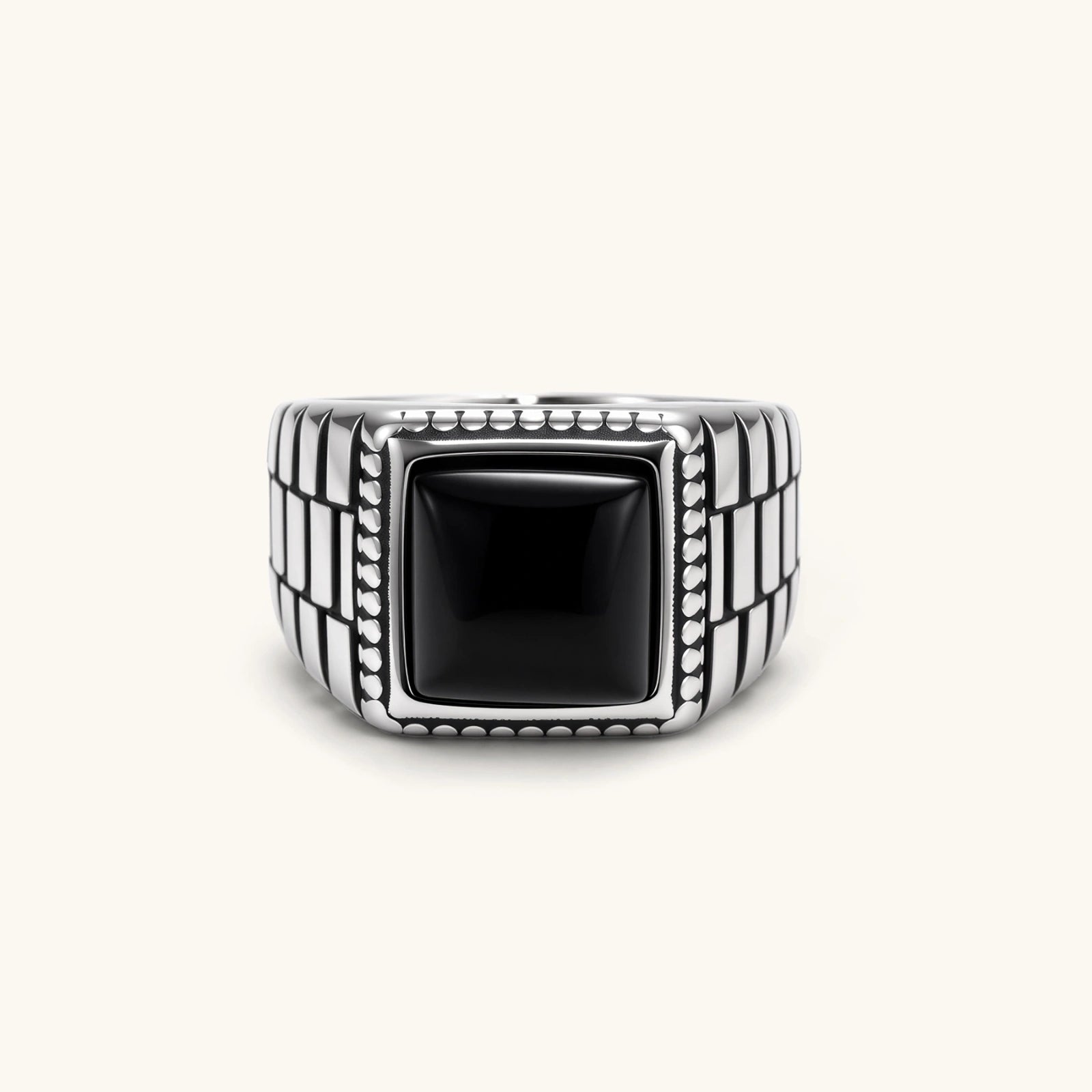 Silver stainless steel signet ring with checkered band texture, beaded border, and square black onyx cabochon stone center.